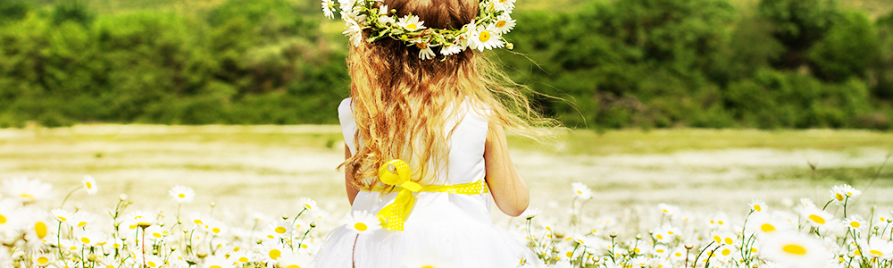 little girl in a meadow surrounded with flowers